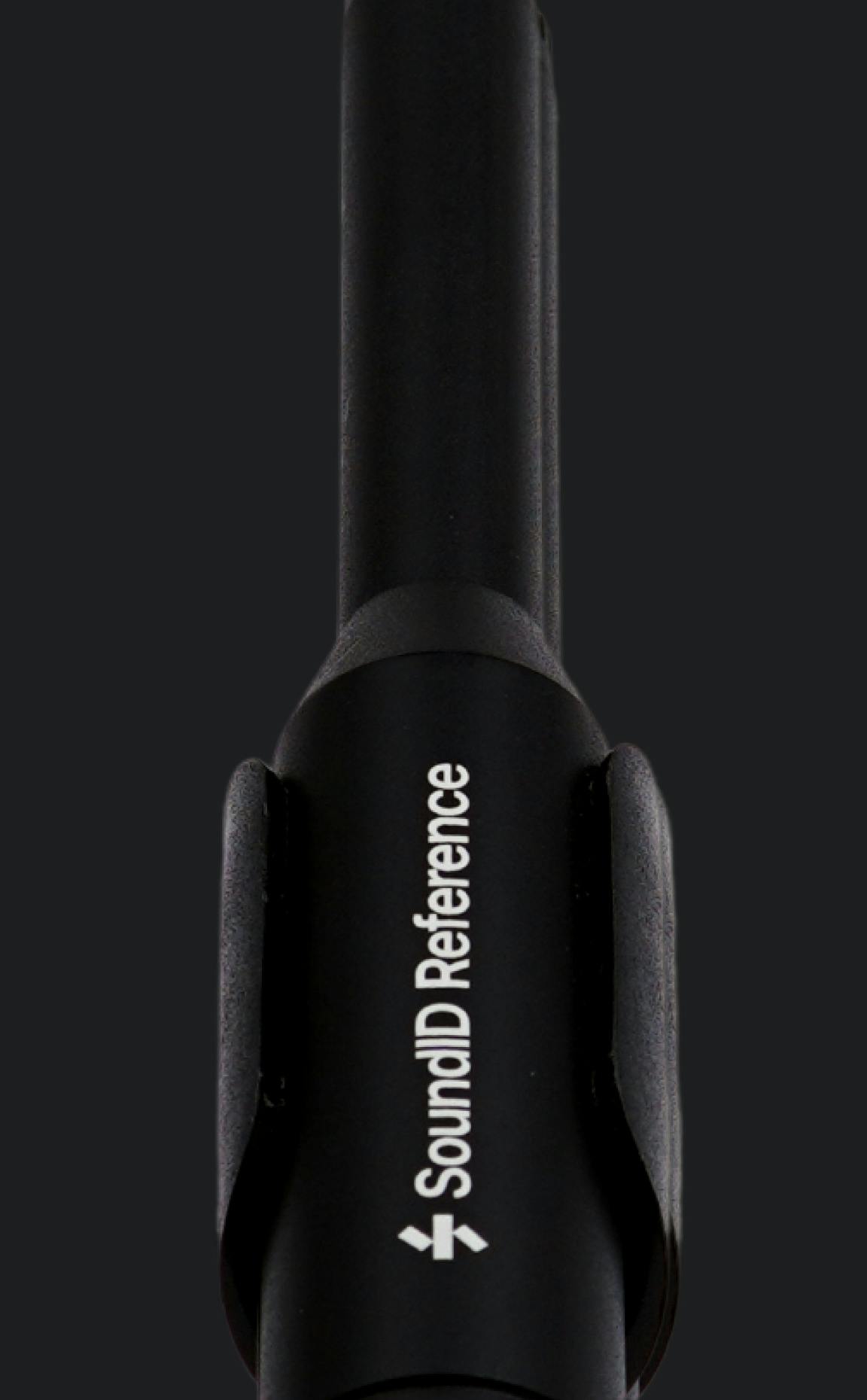 Close-up of black SoundID Reference measurement microphone with logo visible, mounted against dark background.