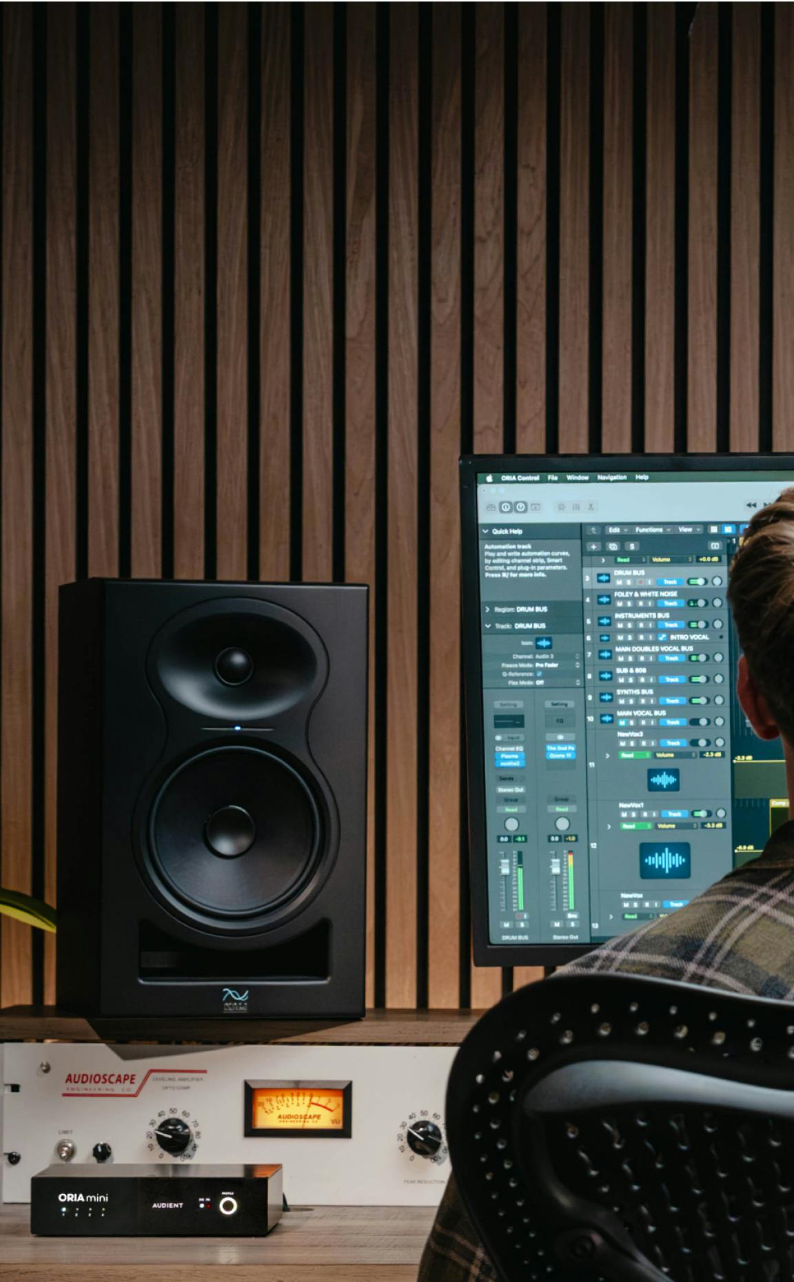 Home studio with black nearfield monitor, DAW mix on screen, Audient ORIA mini and Audioscape VU meter on desk.